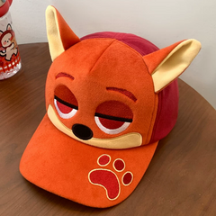 Plush fox baseball cap with embroidered eyes, nose, paw print, and 3D fox ears in soft velvety fabric.