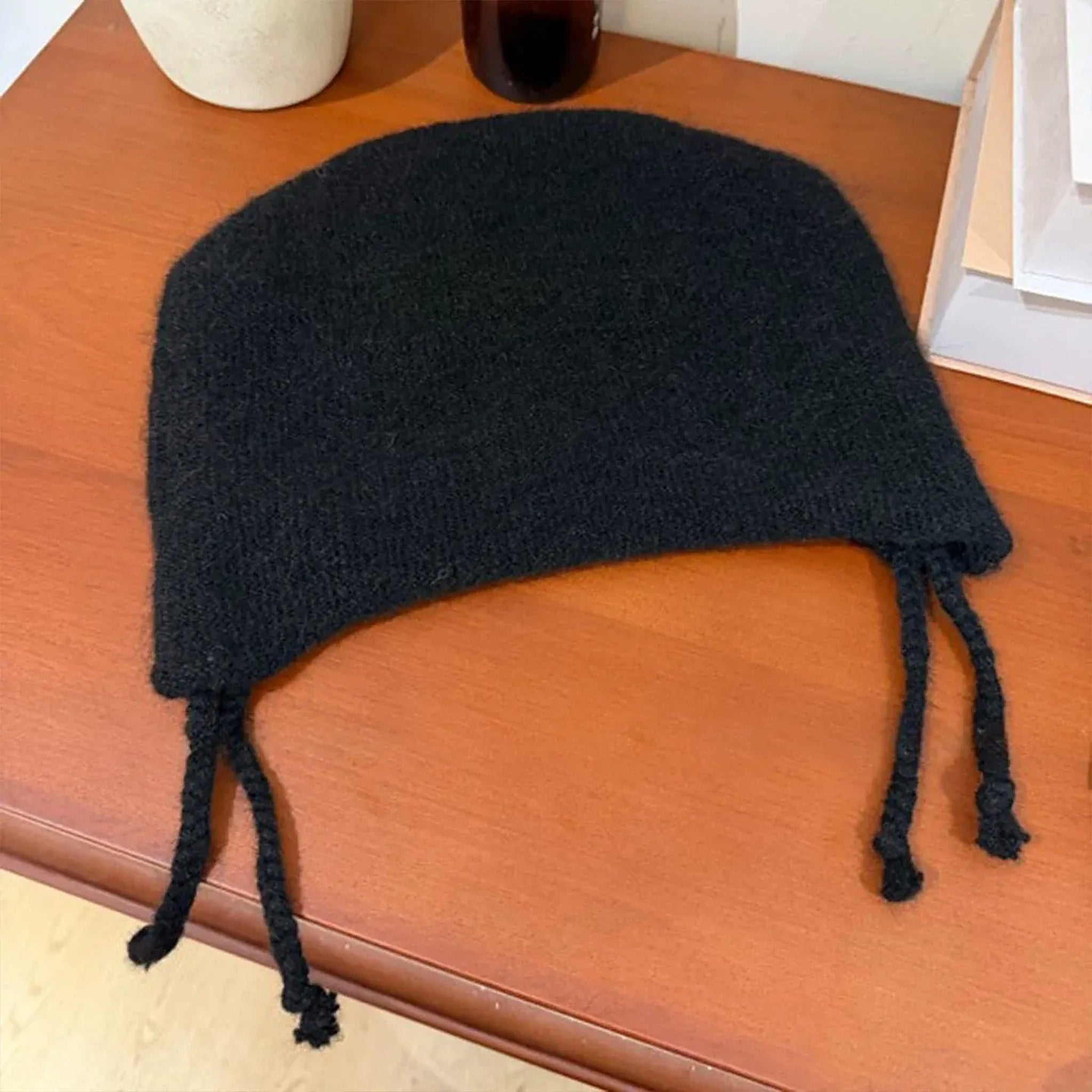 Black cat ear beanie laid flat showing the two braided ties