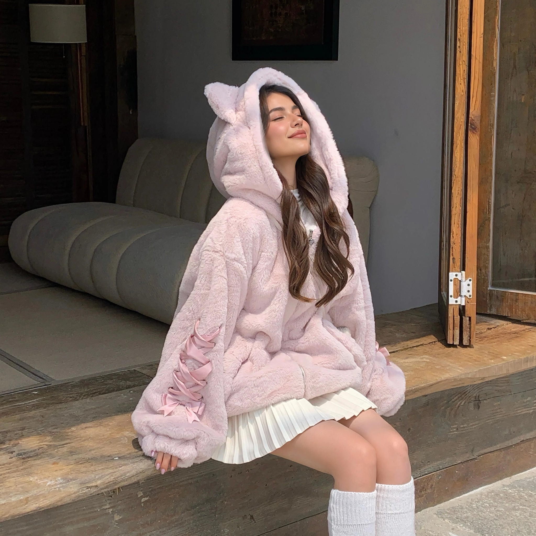 Cat Ear Hood Fluffy Zip Jacket with Ribbon Sleeves in pink, worn sitting in a sunny doorway
