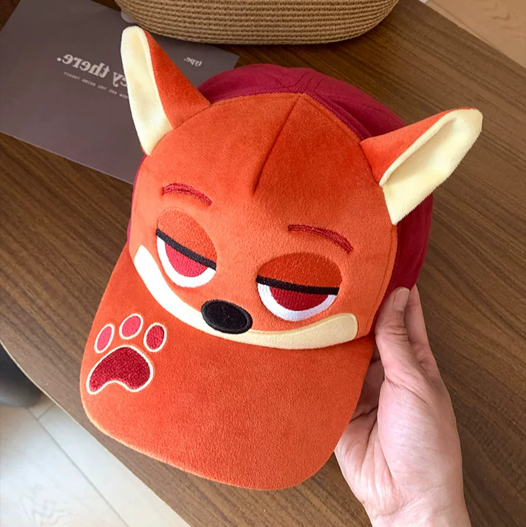 Plush fox baseball cap with embroidered eyes, nose, paw print, and 3D fox ears in soft velvety fabric.