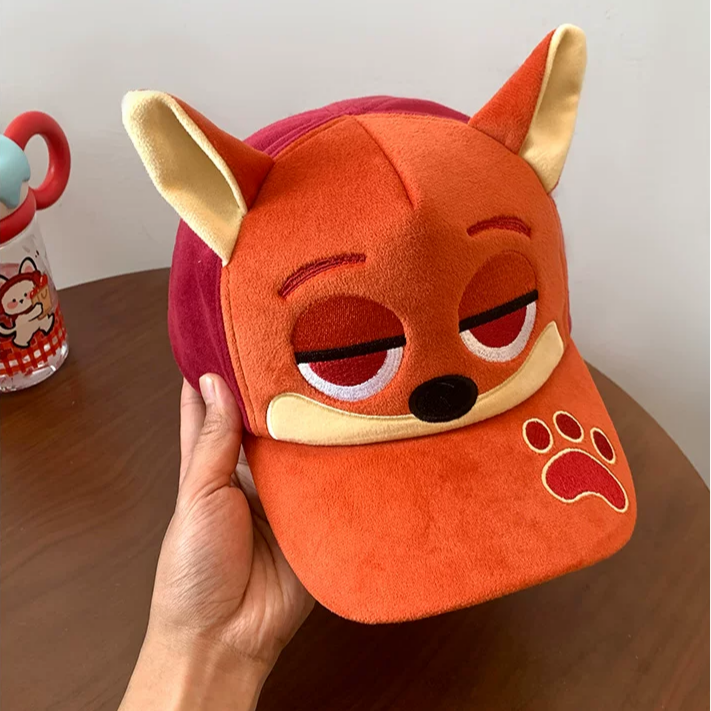 Plush fox baseball cap with embroidered eyes, nose, paw print, and 3D fox ears in soft velvety fabric.